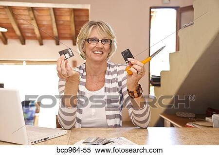 Woman at home office cutting up credit cards View Large Photo Image Stock Photography - Woman at home office cutting up credit cards. Fotosearch