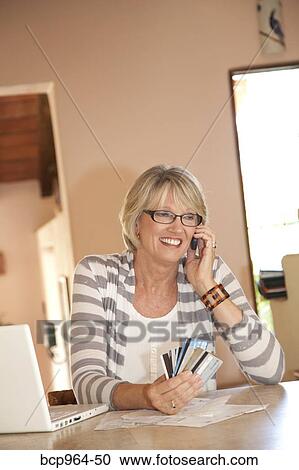 Woman at home office on phone with credit cards View Large Photo Image Stock Image - Woman at home office on phone with credit cards. Fotosearch
