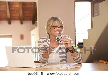 Woman at home office with credit cards View Large Photo Image Stock Image - Woman at home office with credit cards. Fotosearch