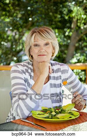 Woman eating salad outdoors View Large Photo Image Picture - Woman eating salad outdoors. Fotosearch