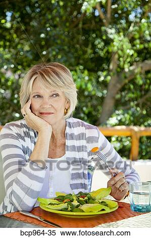 Woman eating salad outdoors View Large Photo Image Stock Photography - Woman eating salad outdoors. Fotosearch