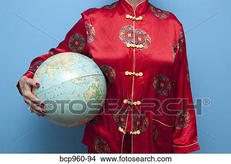 Picture - Woman in Chinese pajamas holding globe. Fotosearch