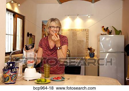 Woman making smoothie in kitchen blender View Large Photo Image Stock Photo - Woman making smoothie in kitchen blender. Fotosearch