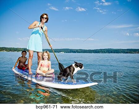 Woman on paddle board with kids and dog View Large Photo Image Stock Image - Woman on paddle board with kids and dog. Fotosearch