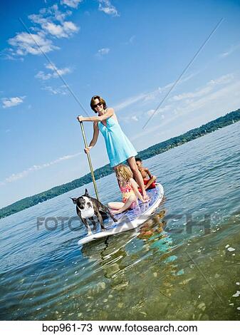 Woman on paddle board with kids and dog View Large Photo Image Stock Image - Woman on paddle board with kids and dog. Fotosearch