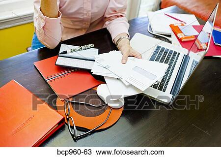 Stock Image - Woman paying bills. Fotosearch