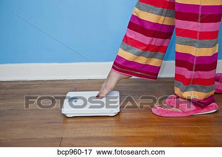 Woman putting toe on scales View Large Photo Image Stock Photo - Woman putting toe on scales. Fotosearch