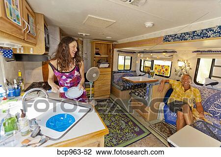 Woman washing dishes in camper while man watches View Large Photo Image Stock Image - Woman washing dishes in camper while man watches. Fotosearch