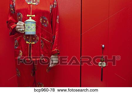 Stock Photo - Woman wearing red silk Chinese pajamas. Fotosearch