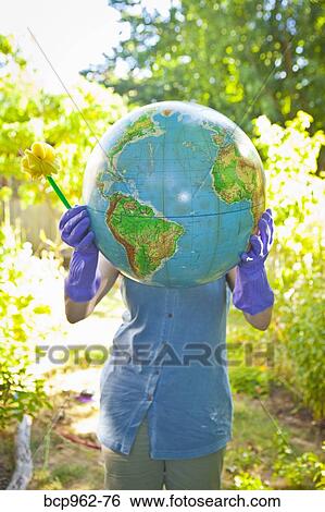 Woman wearing rubber gloves and holding globe View Large Photo Image Stock Photograph - Woman wearing rubber gloves and holding globe. Fotosearch