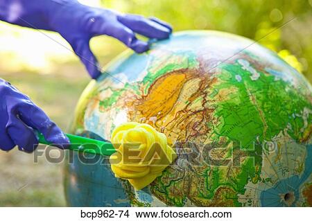 Picture - Woman wearing rubber gloves to scrub globe outdoors. Fotosearch