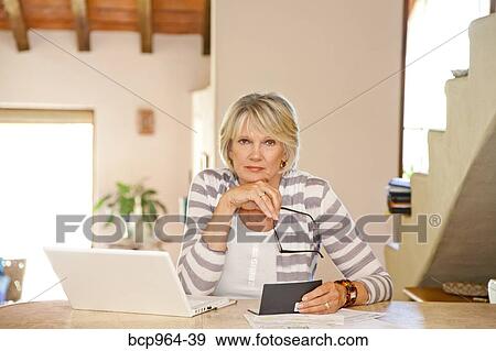 Woman working at home office with computer and bills View Large Photo Image Stock Photo - Woman working at home office with computer and bills. Fotosearch