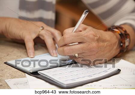 Woman writing checks in home office View Large Photo Image Stock Image - Woman writing checks in home office. Fotosearch