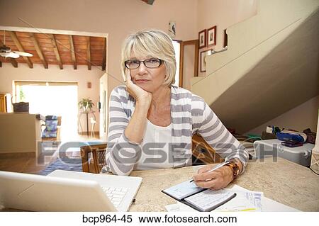 Woman writing checks in home office View Large Photo Image Stock Photography - Woman writing checks in home office. Fotosearch