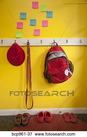 Stock Photo - Yellow wall with colorful post-its and loaded coat hooks. Fotosearch