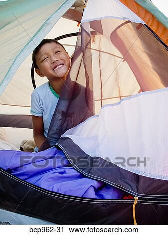 Young boy peeking out from tent on beach at sunrise View Large Photo Image Stock Image - Young boy peeking out from tent on beach at sunrise. Fotosearch