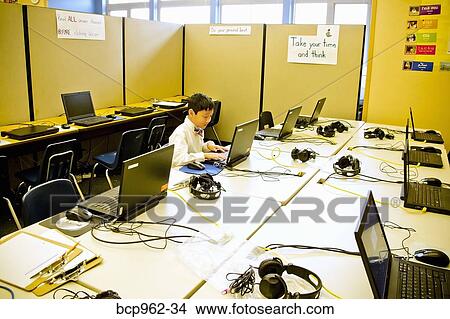 Young boy seated at school laptop in computer lab View Large Photo Image Picture - Young boy seated at school laptop in computer lab. Fotosearch