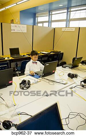 Young boy seated at school laptop in computer lab View Large Photo Image Stock Photo - Young boy seated at school laptop in computer lab. Fotosearch