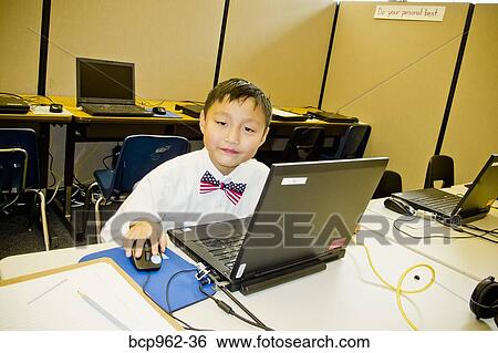 Young boy seated at school laptop in computer lab View Large Photo Image Stock Photograph - Young boy seated at school laptop in computer lab. Fotosearch
