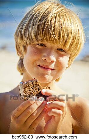 Young boy taking bite of large brownie View Large Photo Image Stock Image - Young boy taking bite of large brownie. Fotosearch