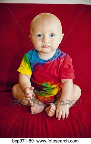 Baby boy sitting on red sofa View Large Photo Image Stock Photo - Baby boy sitting on red sofa. Fotosearch