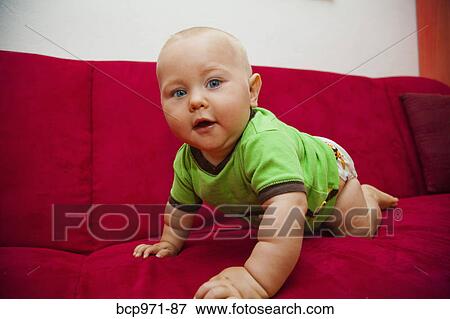 Baby crawling on red sofa View Large Photo Image Stock Photo - Baby crawling on red sofa. Fotosearch