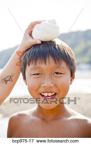 Boy with moonsnail shell on his head View Large Photo Image Stock Photo - Boy with moonsnail shell on his head. Fotosearch