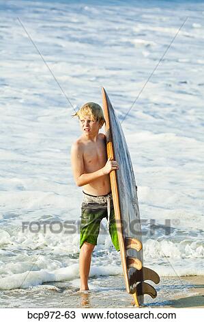 Boy with surfboard on beach View Large Photo Image Stock Image - Boy with surfboard on beach. Fotosearch