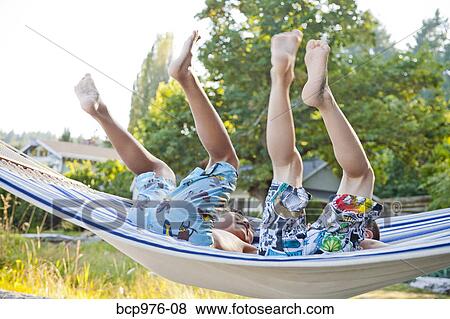 Stock Photo - Children playing in hammock on beach. Fotosearch