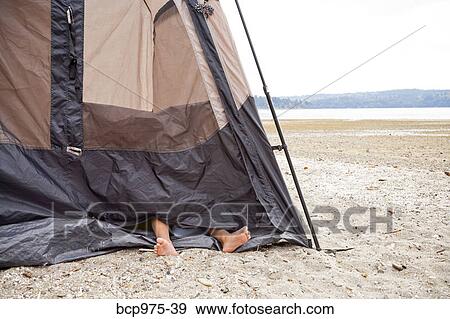 Stock Photo - Child's feet sticking out of tent on beach. Fotosearch