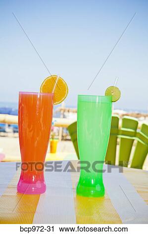 Stock Image - Colorful drinks on seaside table. Fotosearch