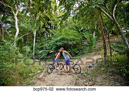 Couple riding bicycles on jungle path View Large Photo Image Stock Image - Couple riding bicycles on jungle path. Fotosearch