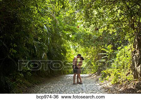Stock Photograph - Couple walking down tree arched path. Fotosearch