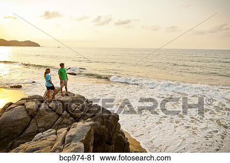 Couple with dog hiking on beach rocks View Large Photo Image Stock Image - Couple with dog hiking on beach rocks. Fotosearch