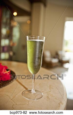 Stock Image - Drink in tall flute glass on table. Fotosearch