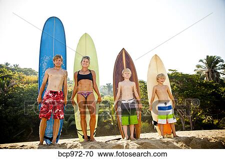 Family of four standing in front of surfboards View Large Photo Image Stock Image - Family of four standing in front of surfboards. Fotosearch