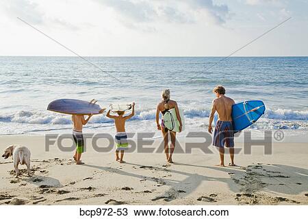 Family on beach holding surfboards View Large Photo Image Stock Image - Family on beach holding surfboards. Fotosearch