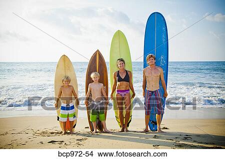 Family standing on beach with surfboards View Large Photo Image Picture - Family standing on beach with surfboards. Fotosearch