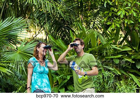 Man and woman bird watching in jungle View Large Photo Image Stock Image - Man and woman bird watching in jungle. Fotosearch