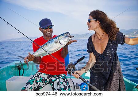 Stock Photograph - Man and woman on charter fishing boat. Fotosearch