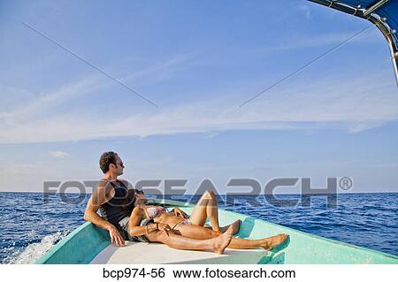 Man and woman relaxing in bow of boat View Large Photo Image Stock Photograph - Man and woman relaxing in bow of boat. Fotosearch