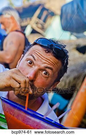 Stock Image - Man drinking oversized cocktail. Fotosearch