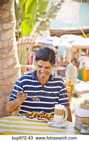 Man eating at outdoor caf View Large Photo Image Stock Image - Man eating at outdoor caf. Fotosearch