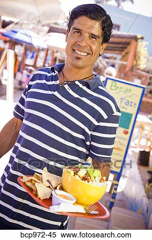 Stock Photography - Man holding plate of mexican food. Fotosearch