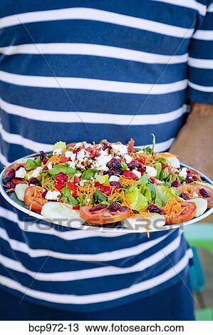 Stock Image - Man holding platter of mexican food. Fotosearch