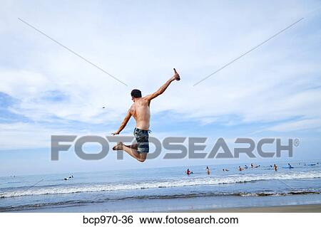 Man leaping in air on beach View Large Photo Image Stock Photograph - Man leaping in air on beach. Fotosearch