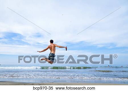 Man leaping in air on beach View Large Photo Image Stock Photography - Man leaping in air on beach. Fotosearch