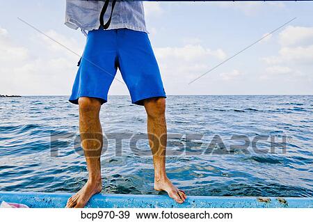 Man standing on edge of boat View Large Photo Image Stock Photo - Man standing on edge of boat. Fotosearch