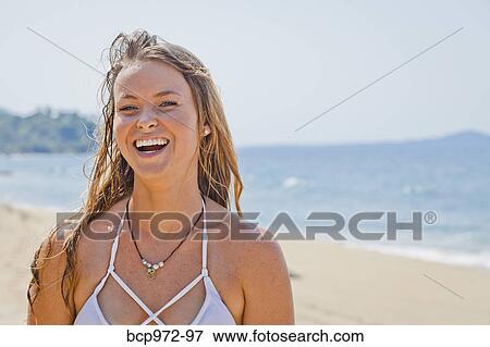 Stock Photo - Portrait of young laughing woman on beach. Fotosearch