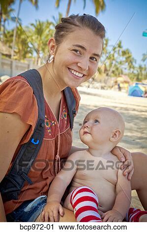 Seated mother holding baby View Large Photo Image Stock Image - Seated mother holding baby. Fotosearch